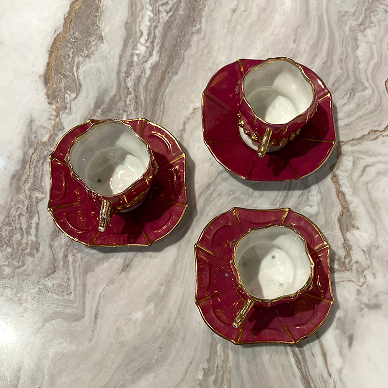 Three cups and sub-cups in red porcelain flashed w/gold