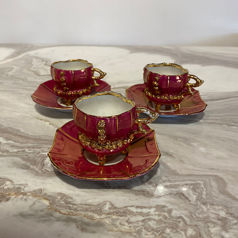 Three cups and sub-cups in red porcelain flashed w/gold